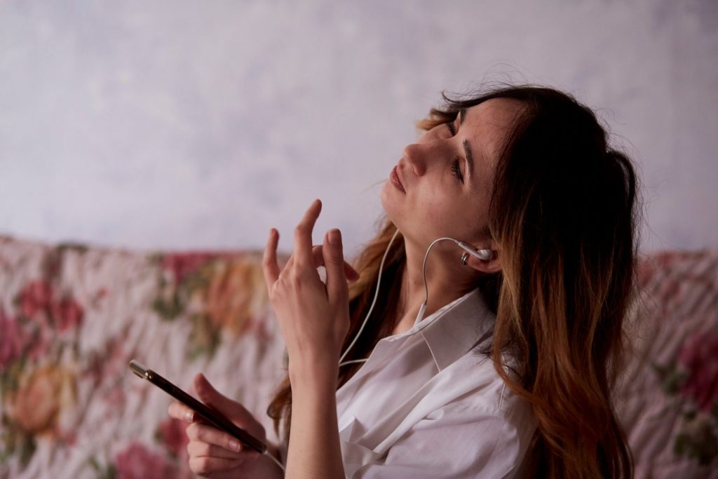 Aesthetic beautiful young woman listen to music in headphones at cozy home.